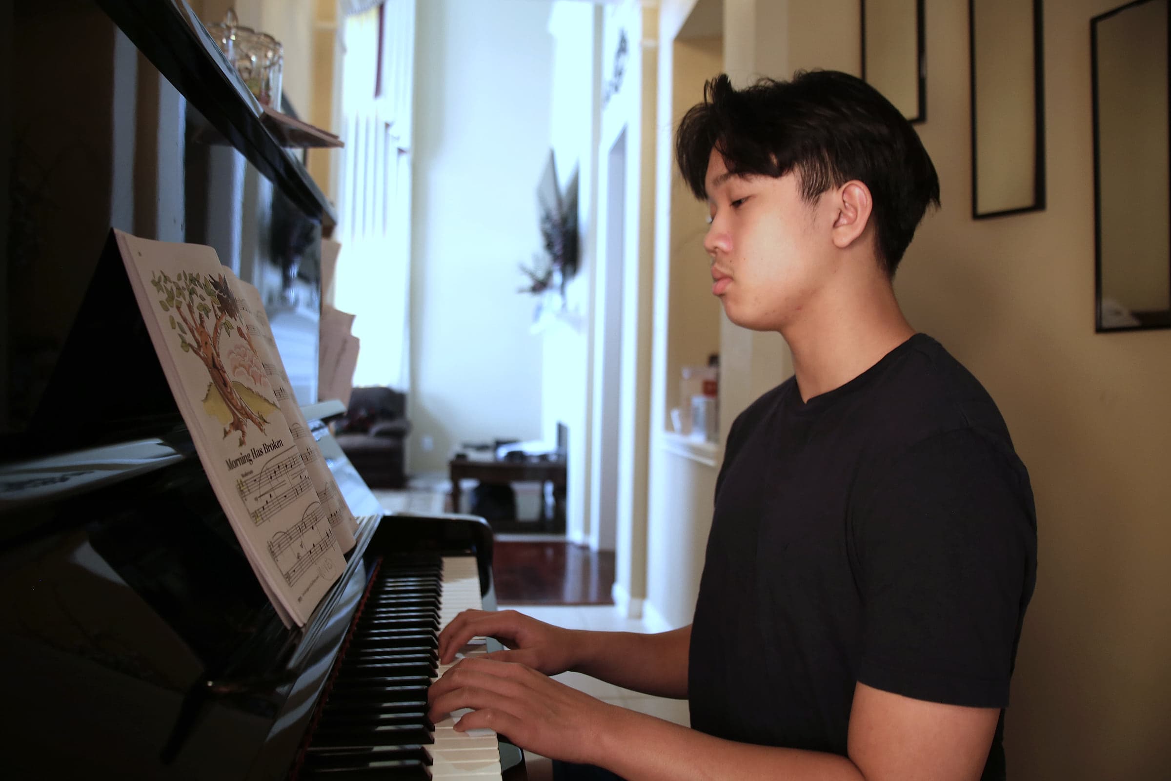 A teenage student reading sheet music while playing